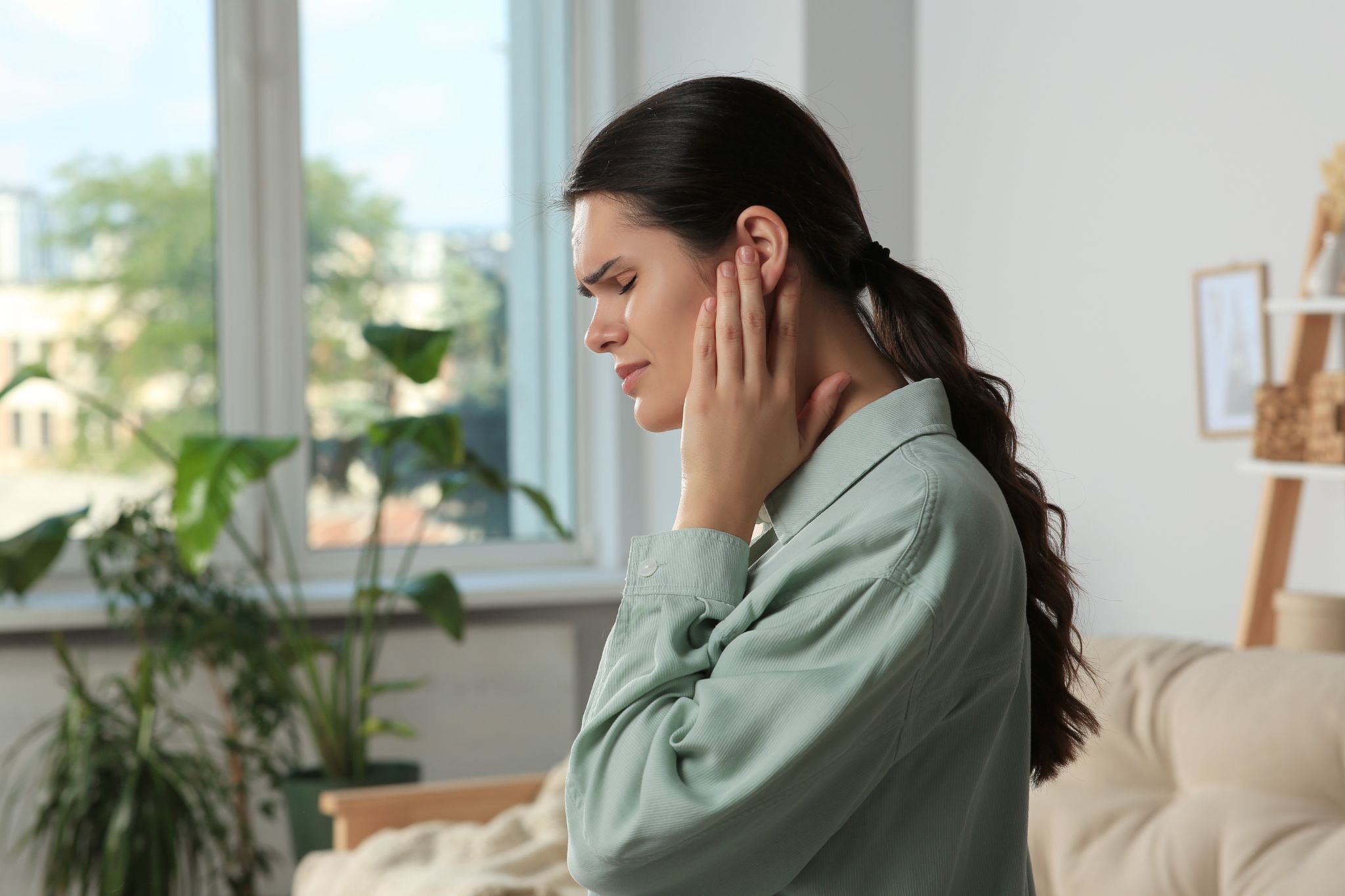 A woman holding her ear in pain