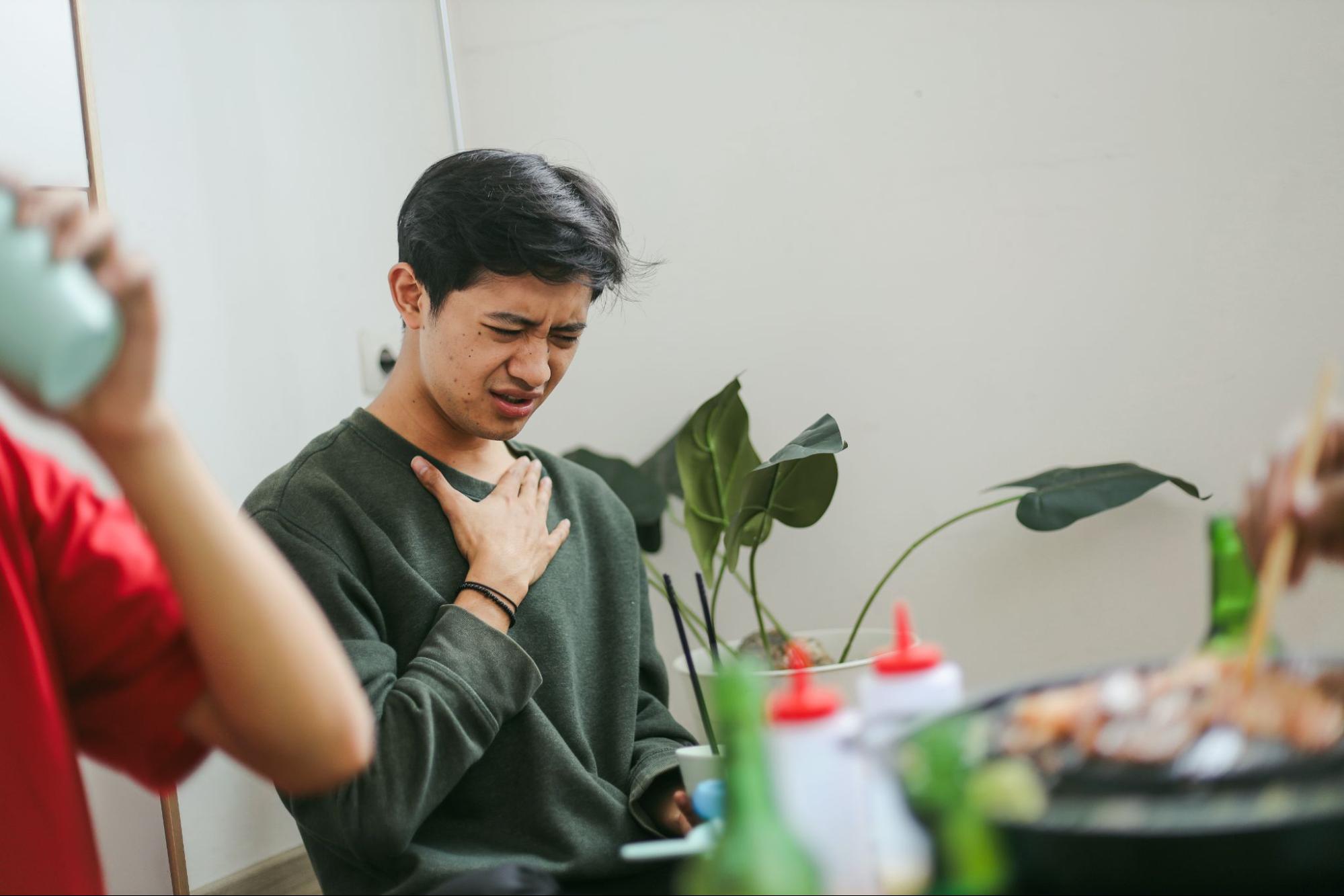 A man holding his chest after eating